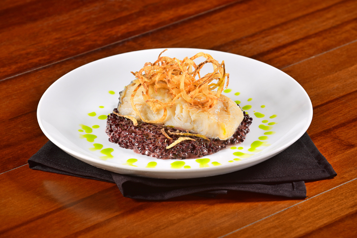 No Bobardí, o tradicional bacalhau é confitado e servido com arroz negro e cebola crisp.