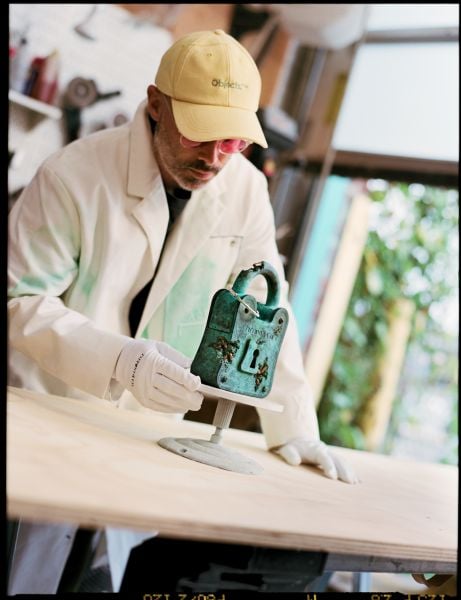 O artista contemporâneo Daniel Arsham examinando a escultura Bronze Eroded Tiffany Padlock (Foto: divulgação)