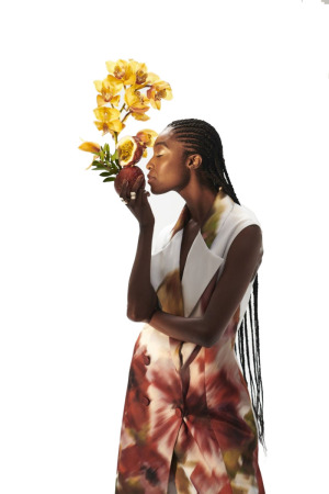 Mulher com macacão branco com estampa de flores vermelha