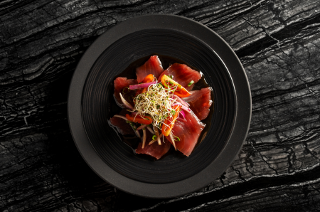 Carpaccio de atum com salada de tomate, cebola roxa e brotos de alfafa.