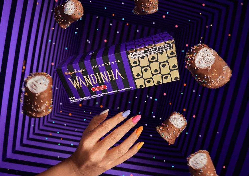 Caixa de chocolate colorida flutuando em um fundo listrado preto e roxo.